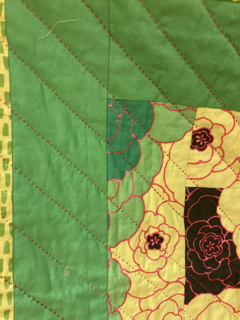 close up of hand stitching on quilt