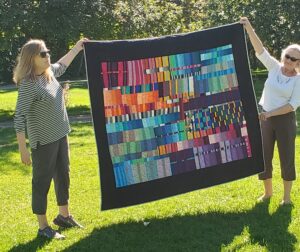 two women holding up modern quilt