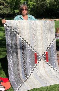 woman holding up quilt