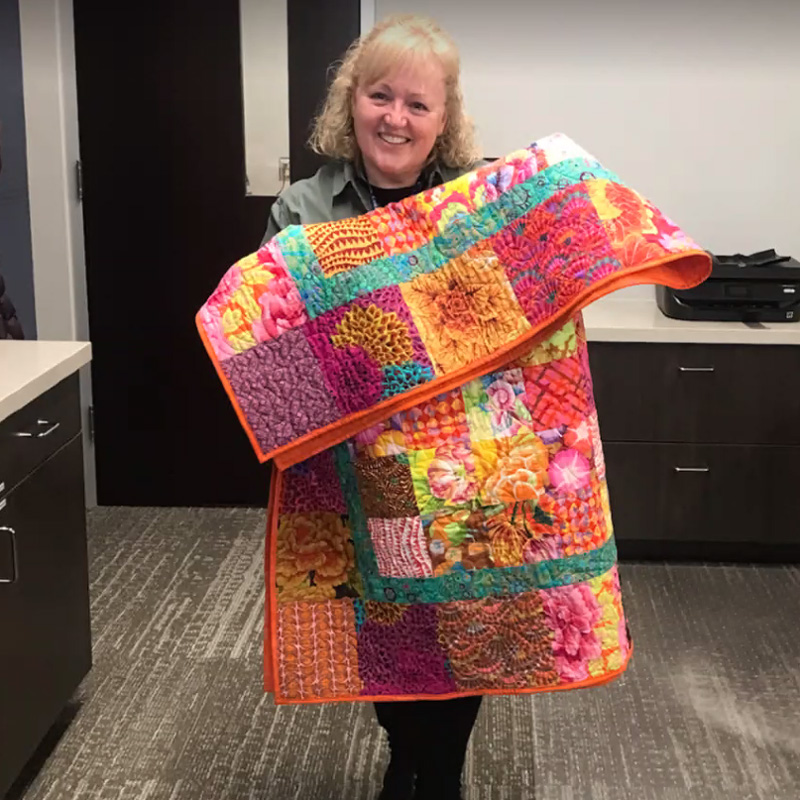 Woman holding bright color quilt